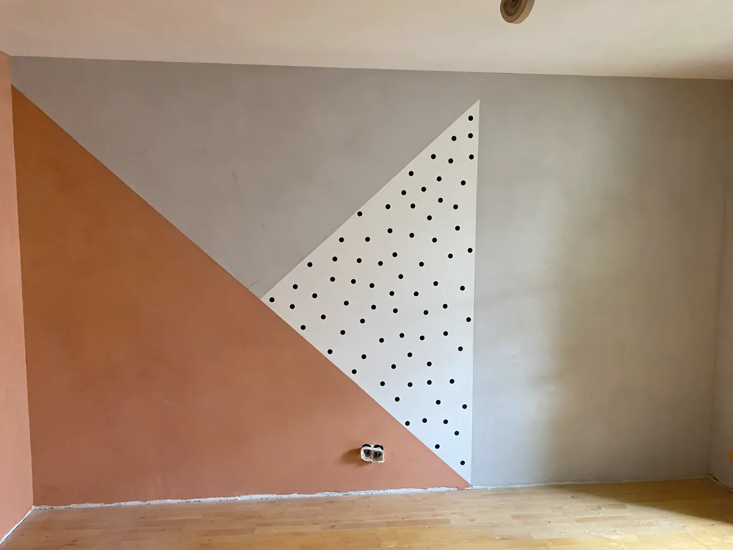 Innenwand mit geometrischem Dreiecksmuster in warmen Farbtönen